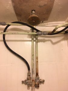 Showerhead and pipes in old bathroom